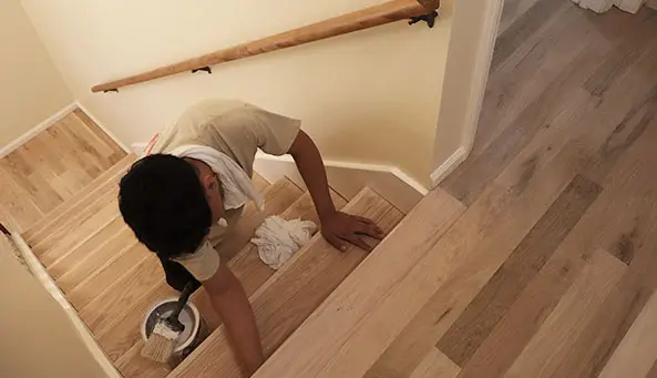 Professional working on hardwood stairs refinishing