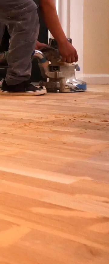 Sanding hardwood floors with professional floor sander machine